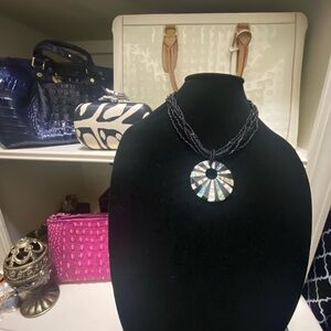 Beautiful necklace with a circular pendant with accents of Pearl-Like rays.
